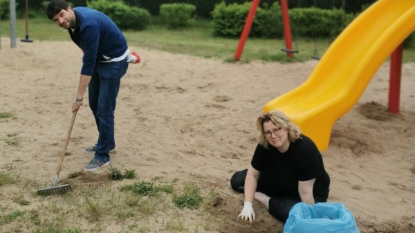 Doreen Radelow und Christian Winter durchforsten den Sand am Spielplatz in der Zeppelinstraße nach Unkraut und Unrat.